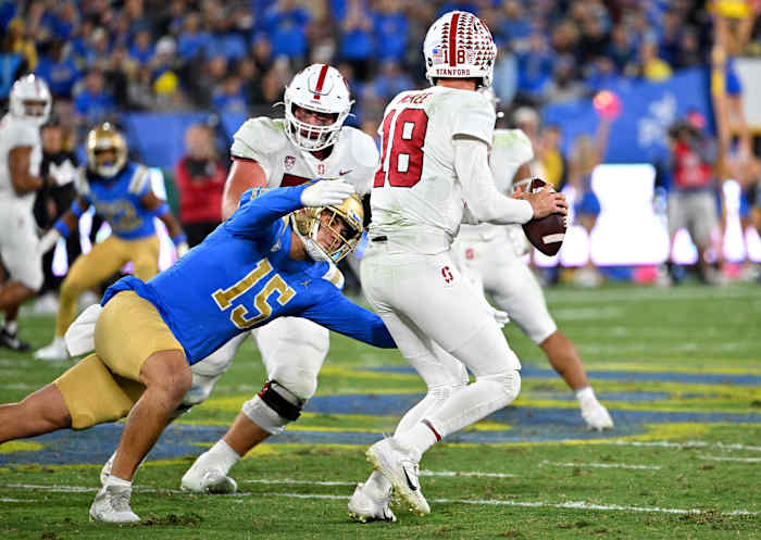 Oct 29, 2022; Pasadena, California, USA; Stanford Cardinal quarterback Tanner McKee (18) is pressured by UCLA Bruins linebacker Laiatu Latu (15) in the first half at the Rose Bowl. Mandatory Credit: Jayne Kamin-Oncea-USA TODAY Sports